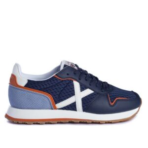 Zapatillas de la marca Munich, modelo Massana 467 en color azul. Zapatilla deportiva de nylon y pieza en el talón bicolor. Contraste de materiales en color en azul marino con detalles en azul claro, blanco y rojo. Cordonera con ocho pasados con logo grabado en la talonera.